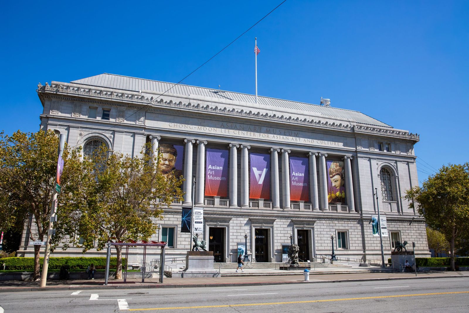 The museum's classical stone building with banners across its columns under a blue sky.