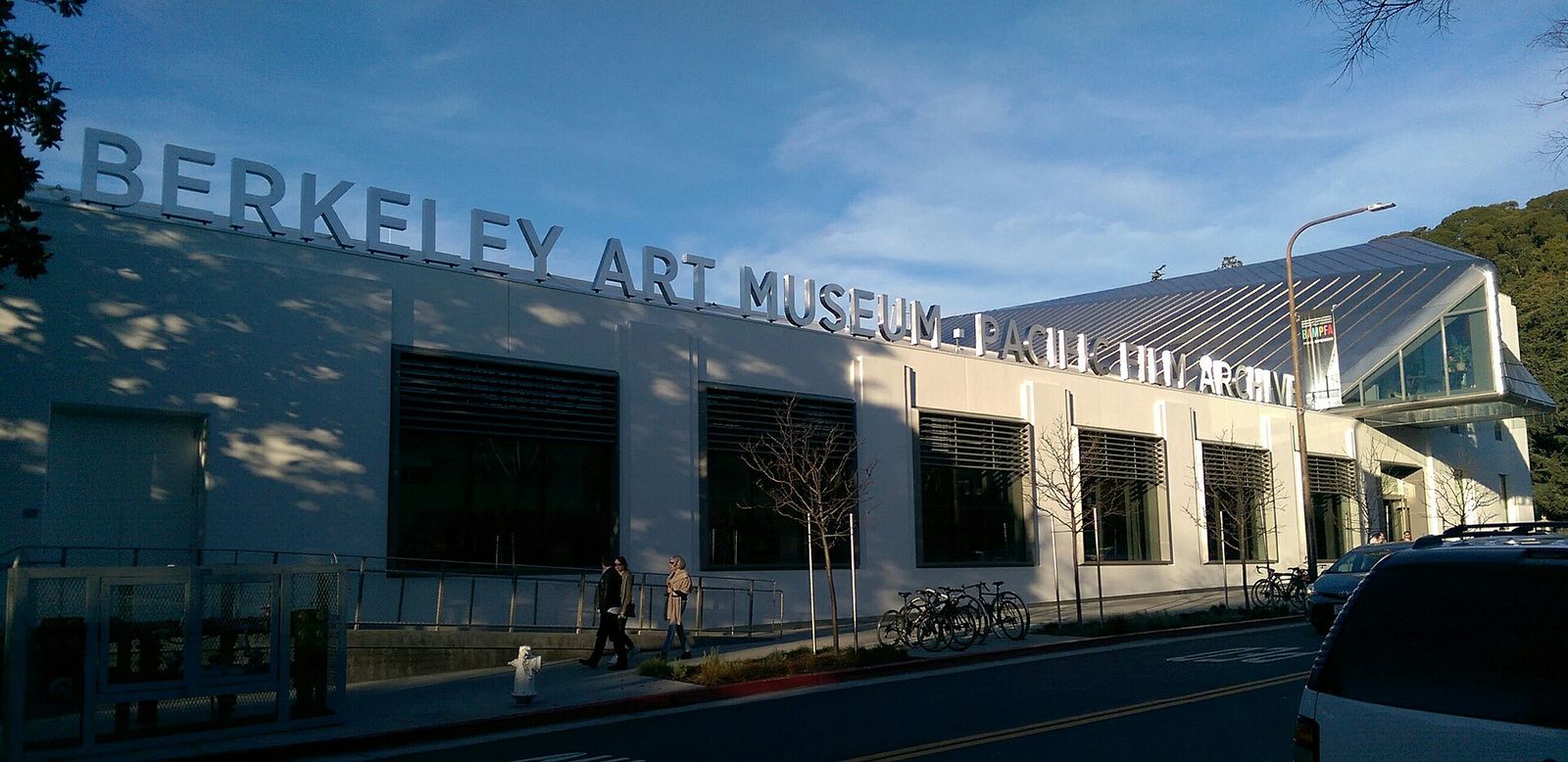 The museum's long building with large lettering reading Berkeley Art Museum along its roof edge, under a blue sky.