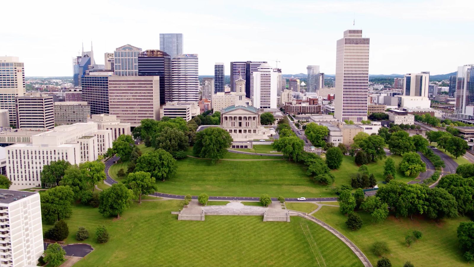 Aerial view of the park's green lawns and paths with the Nashville skyline behind