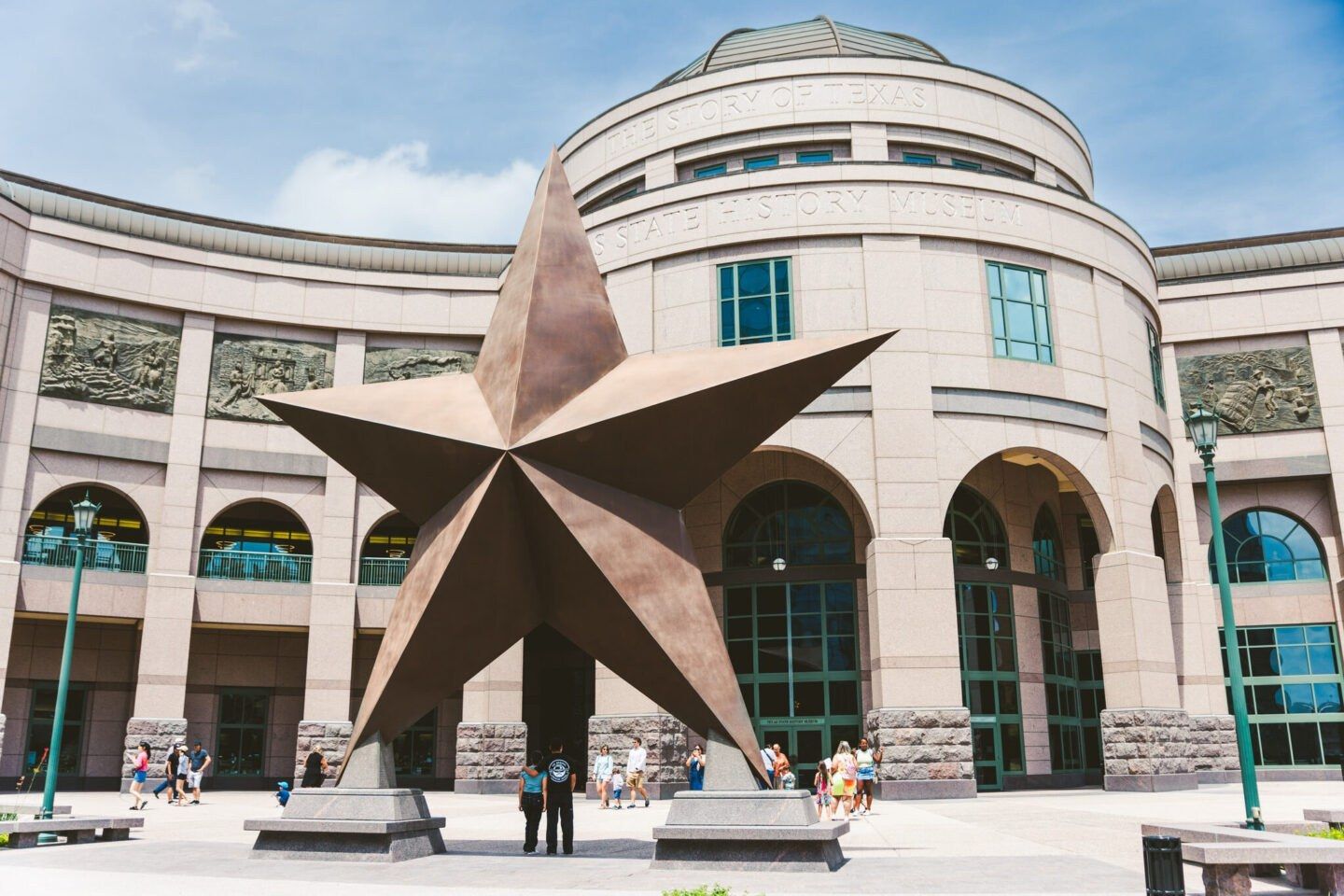 The museum's curved stone building with a large bronze star sculpture in front and arched windows.