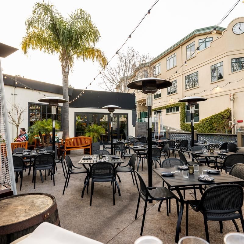 Outdoor patio with tables, heaters and string lights beside the restaurant