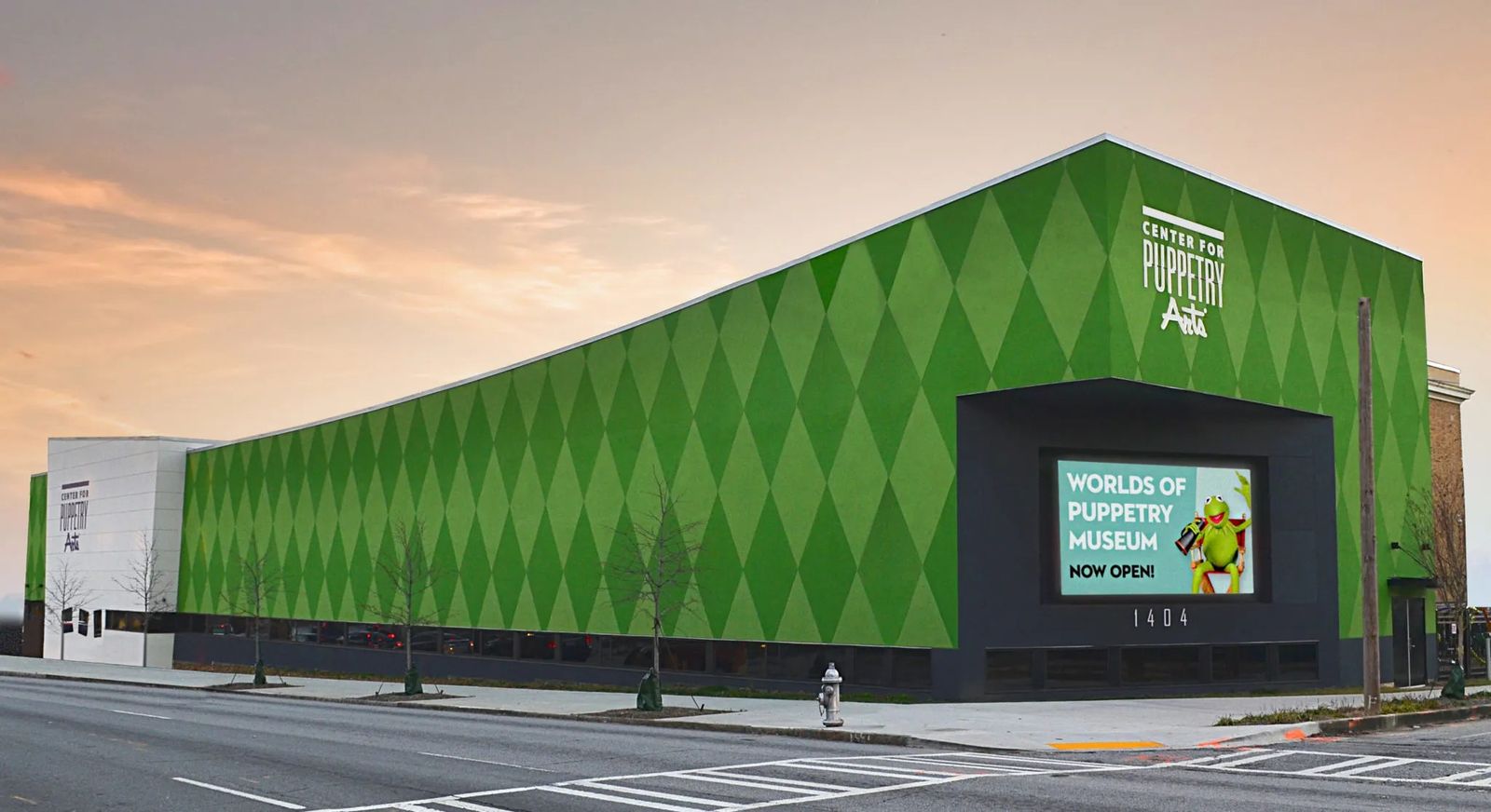 The green diamond-patterned exterior of the Center for Puppetry Arts building at dusk