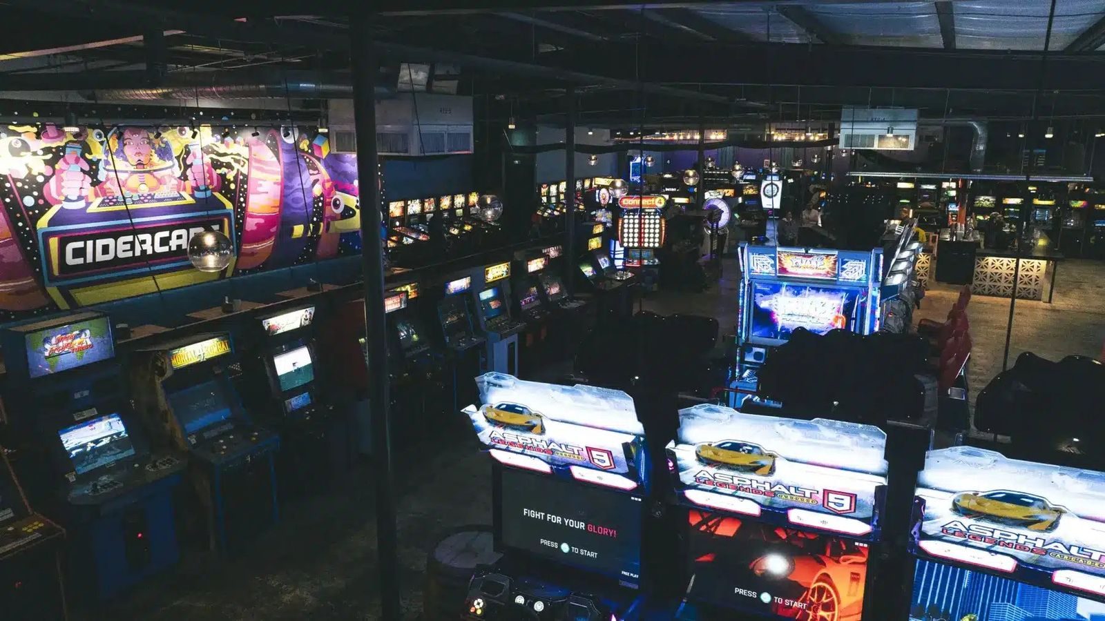Rows of arcade cabinets in a dimly lit game hall