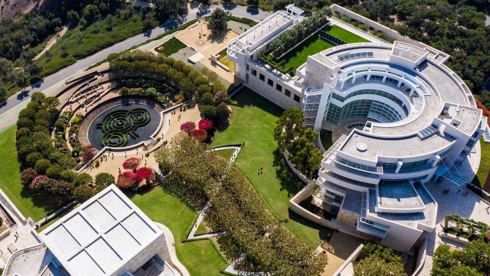 An aerial view of the white hilltop museum campus with its circular buildings and garden.