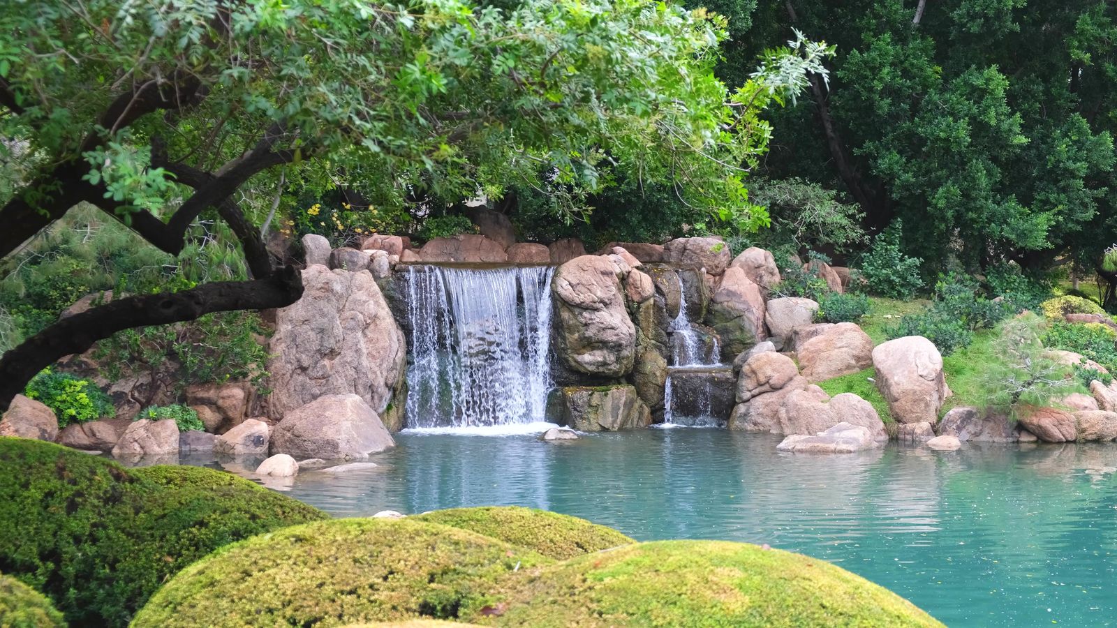 Waterfall and pond with rocks and green plantings