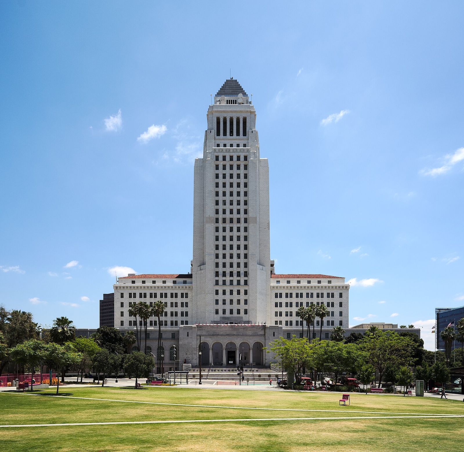 Los Angeles City Hall tower rising above a green lawn under a blue sky