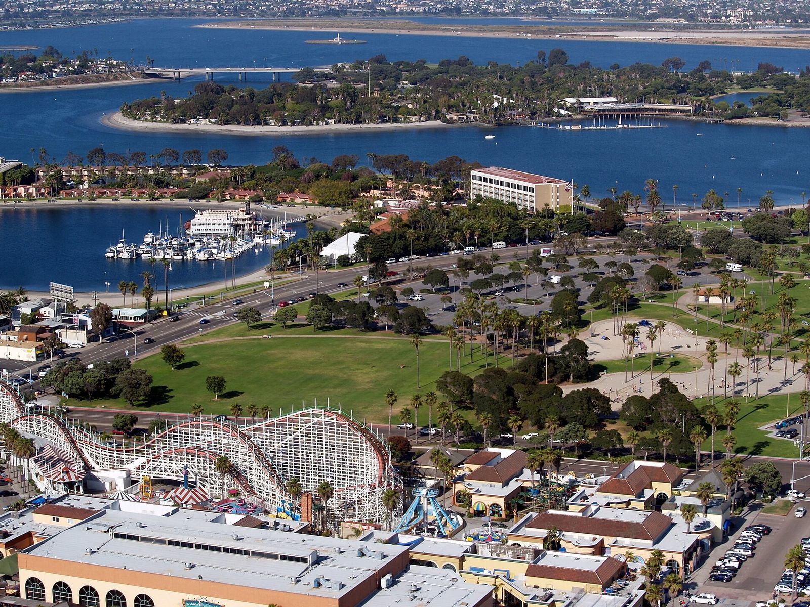 An aerial view of the bay with a coaster and amusement area at the foreground and islands beyond.