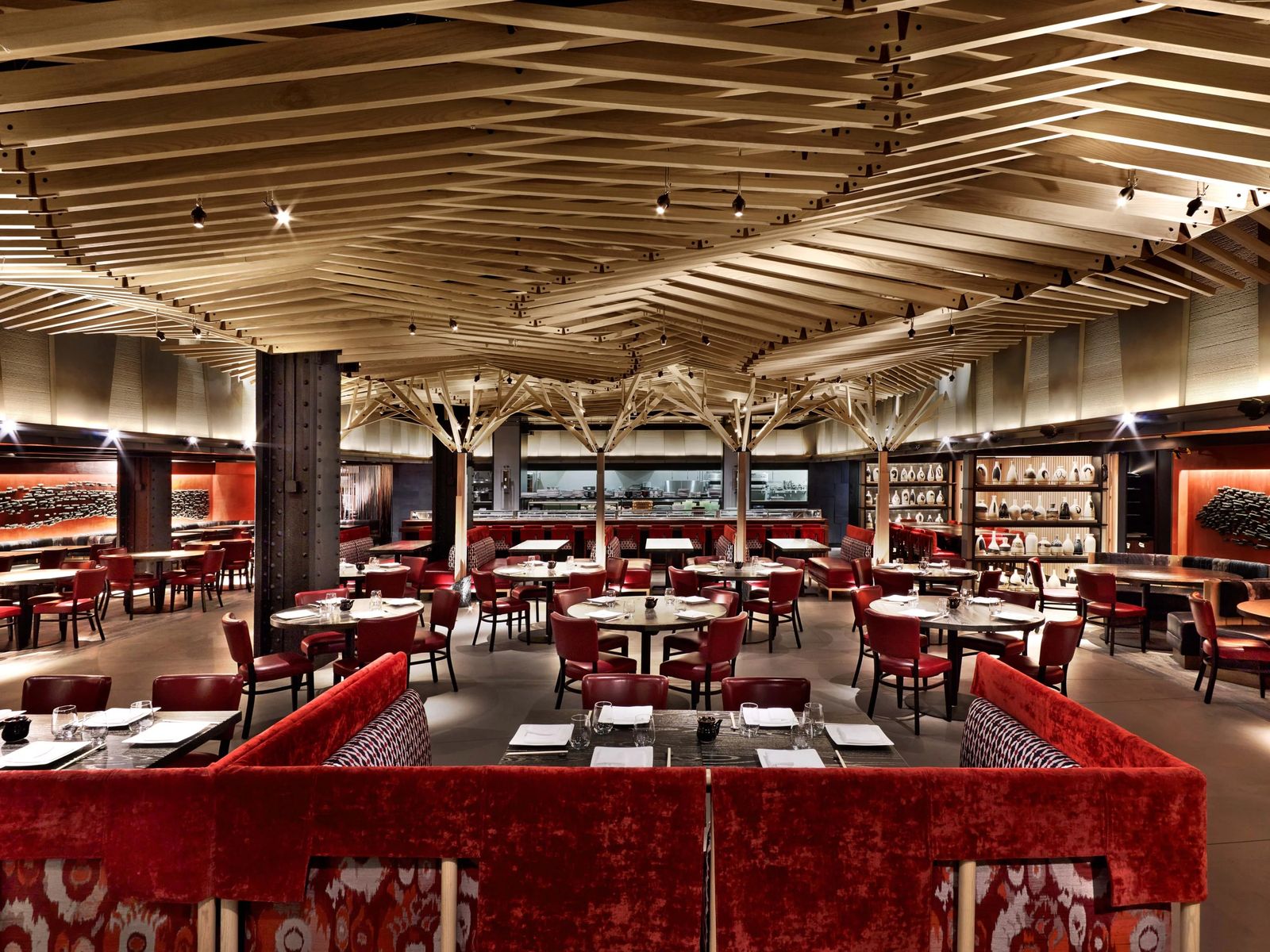 A large dining room with red booths, rows of tables and a sculpted wood ceiling.