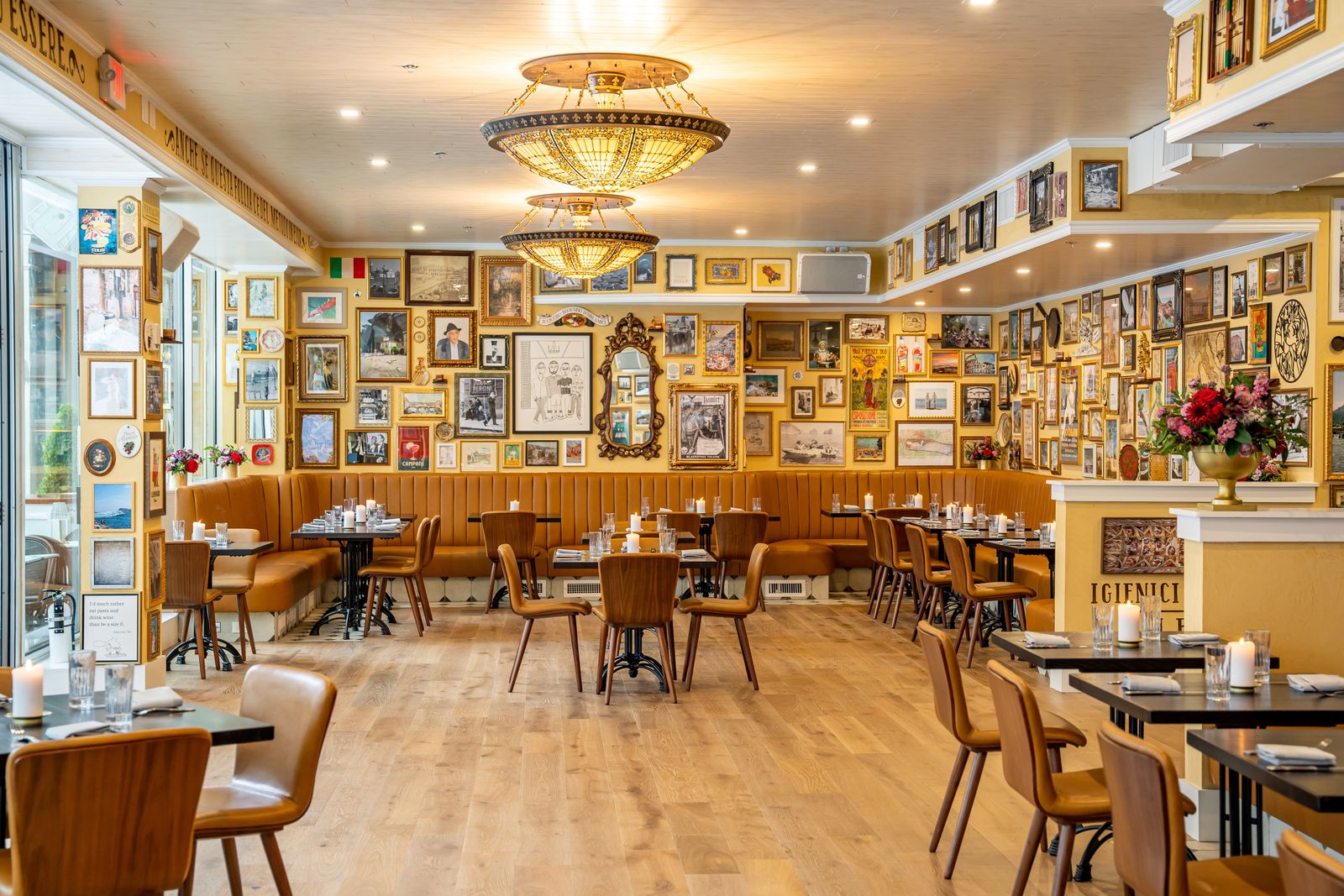 Dining room with a gallery wall of framed pictures, chandeliers and wooden chairs