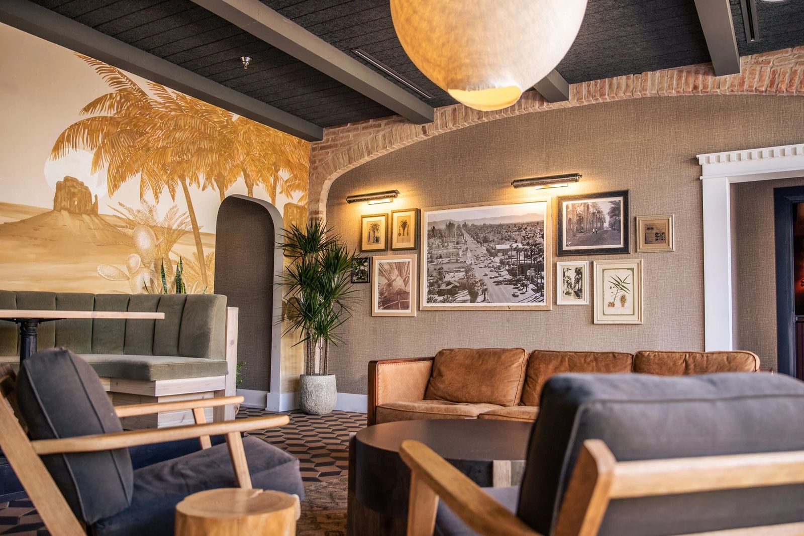 Lounge area with sofas, armchairs and a desert mural behind a bar