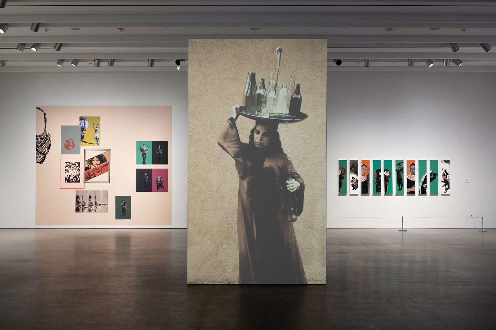 Gallery with pink walls and a tall figure installation on a dark floor