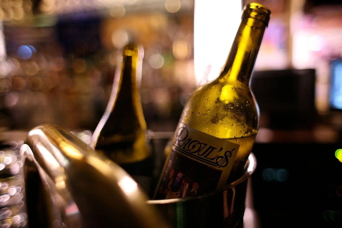 A bottle of wine labelled Raoul's chilling in an ice bucket at the bar
