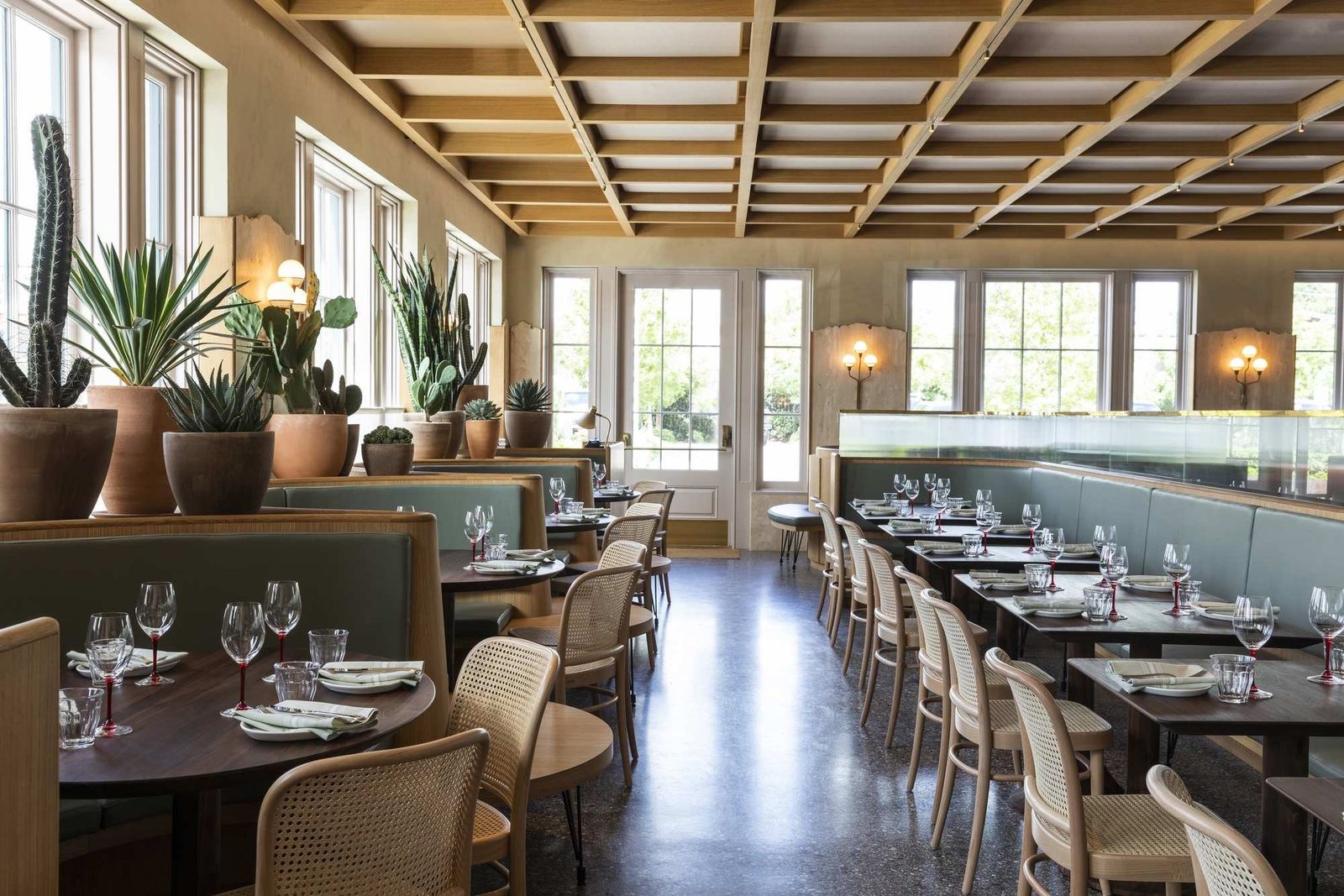Dining room with long tables, wooden coffered ceiling and tall windows