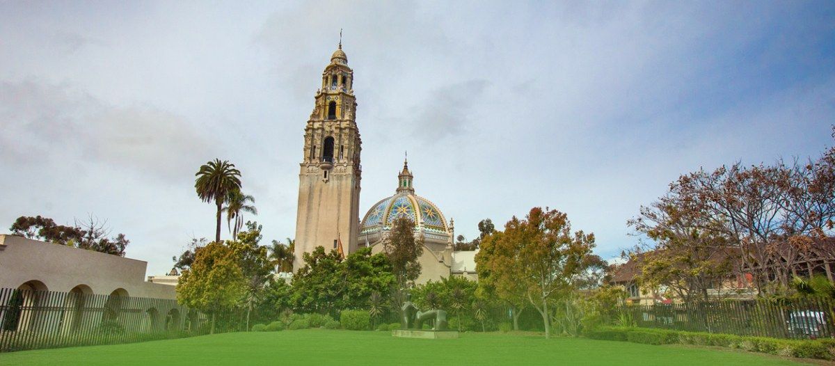 The museum's tower and domed building rising above a green lawn and trees.