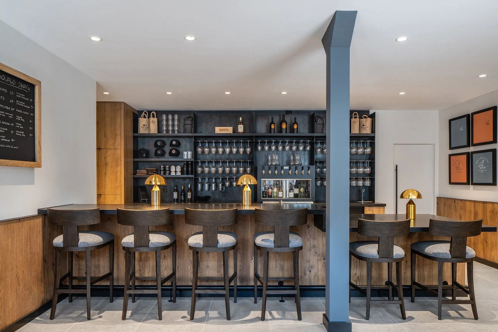 Wine bar interior with stools along a counter and shelves of bottles behind it