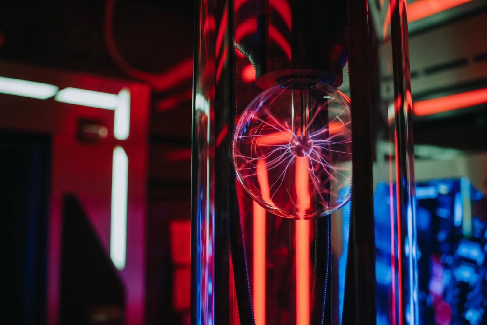 A glowing plasma ball inside a red and blue lit escape room