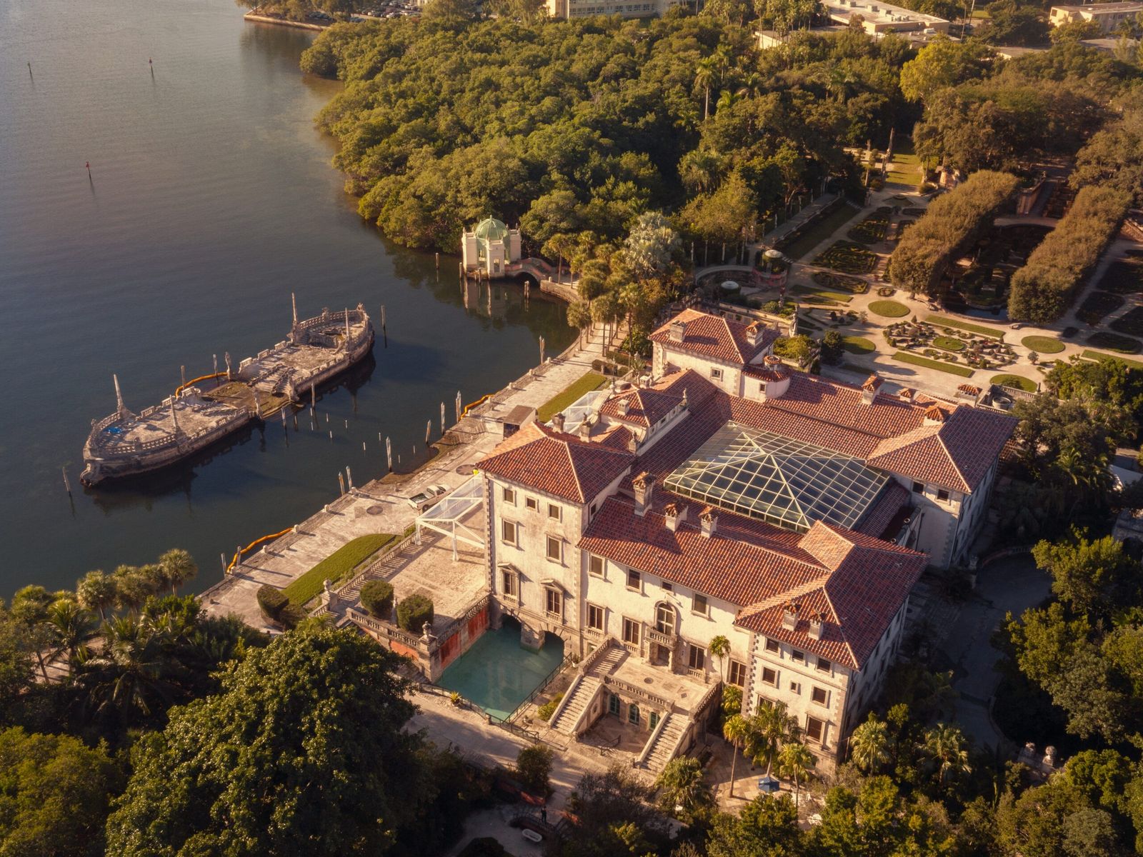 Aerial view of the Vizcaya villa and its gardens beside the bay, surrounded by trees